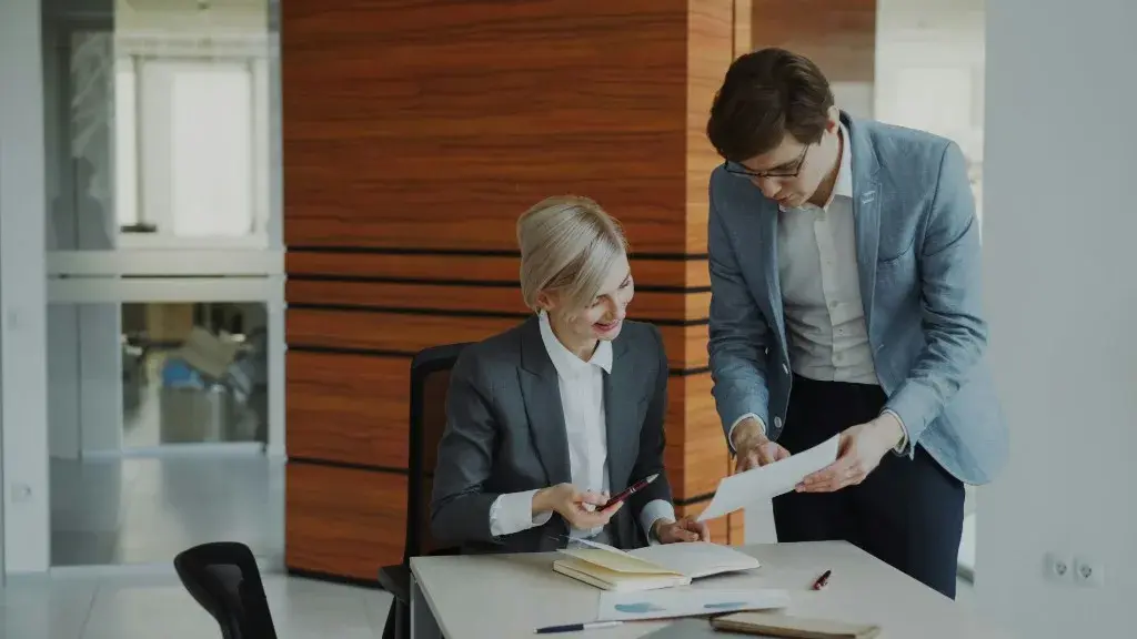 Two professionals reviewing financial documents and charts during a consultation